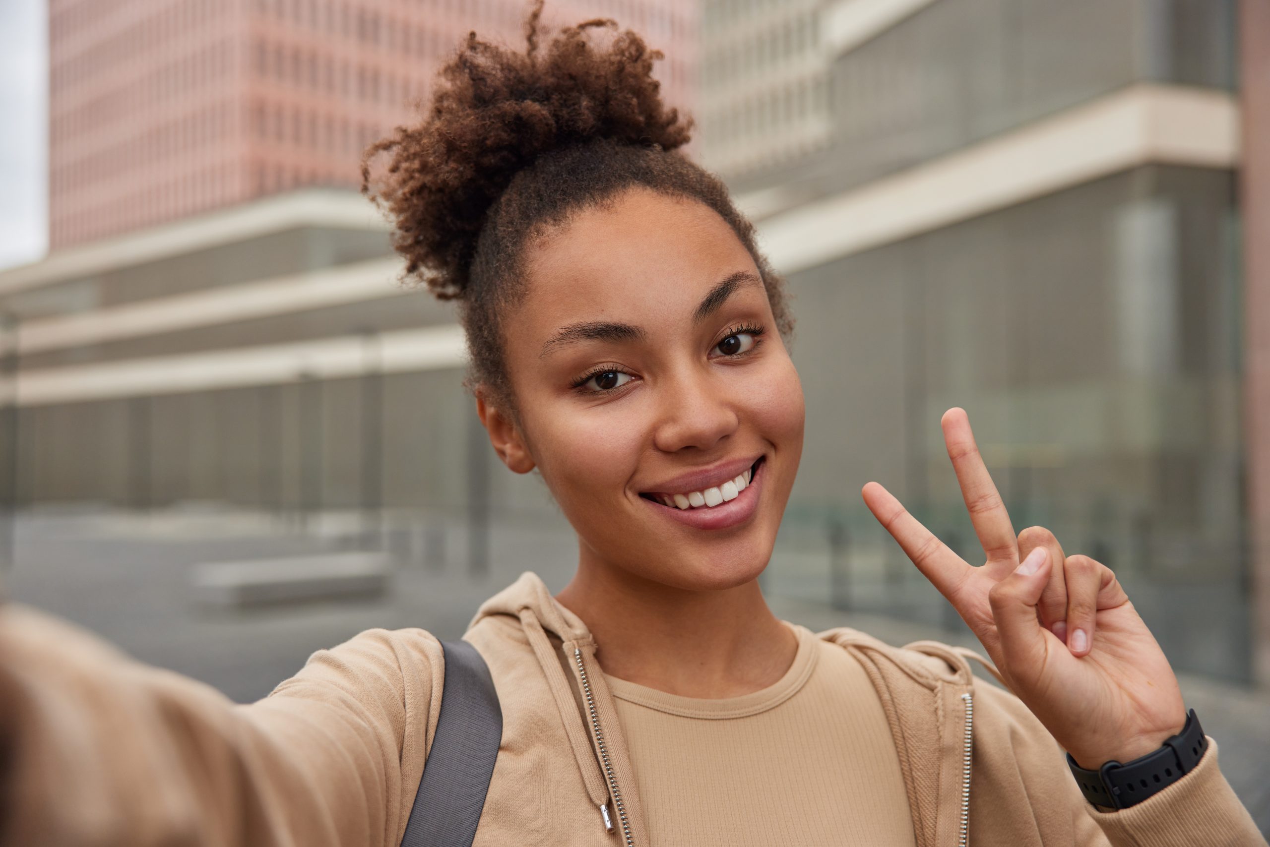 positive carefree woman with curly hair dressed hoodie